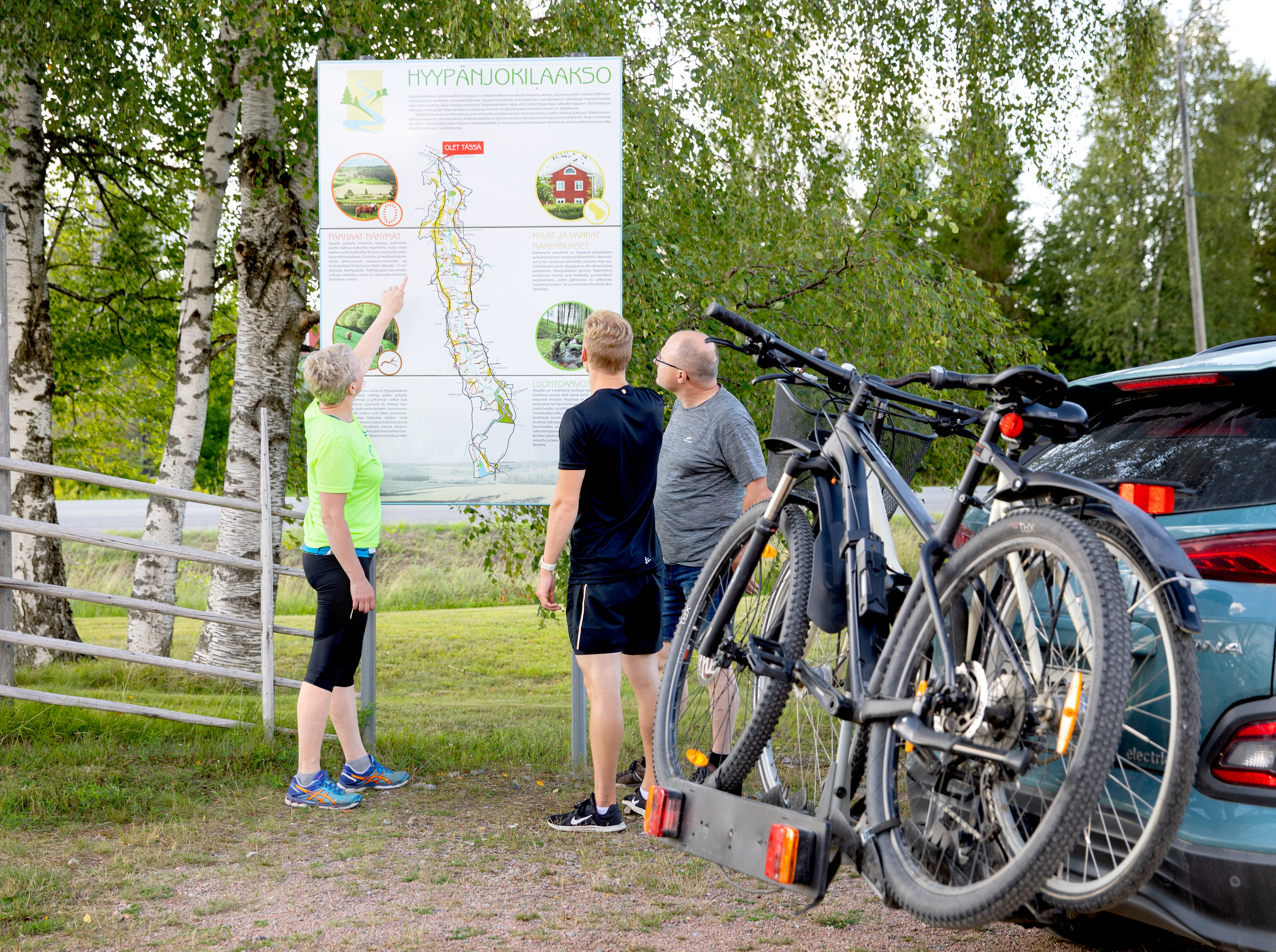 Pyöräilijöitä tutkimassa karttaa kesäpäivänä Hyypänjokilaaksossa Kauhajoella