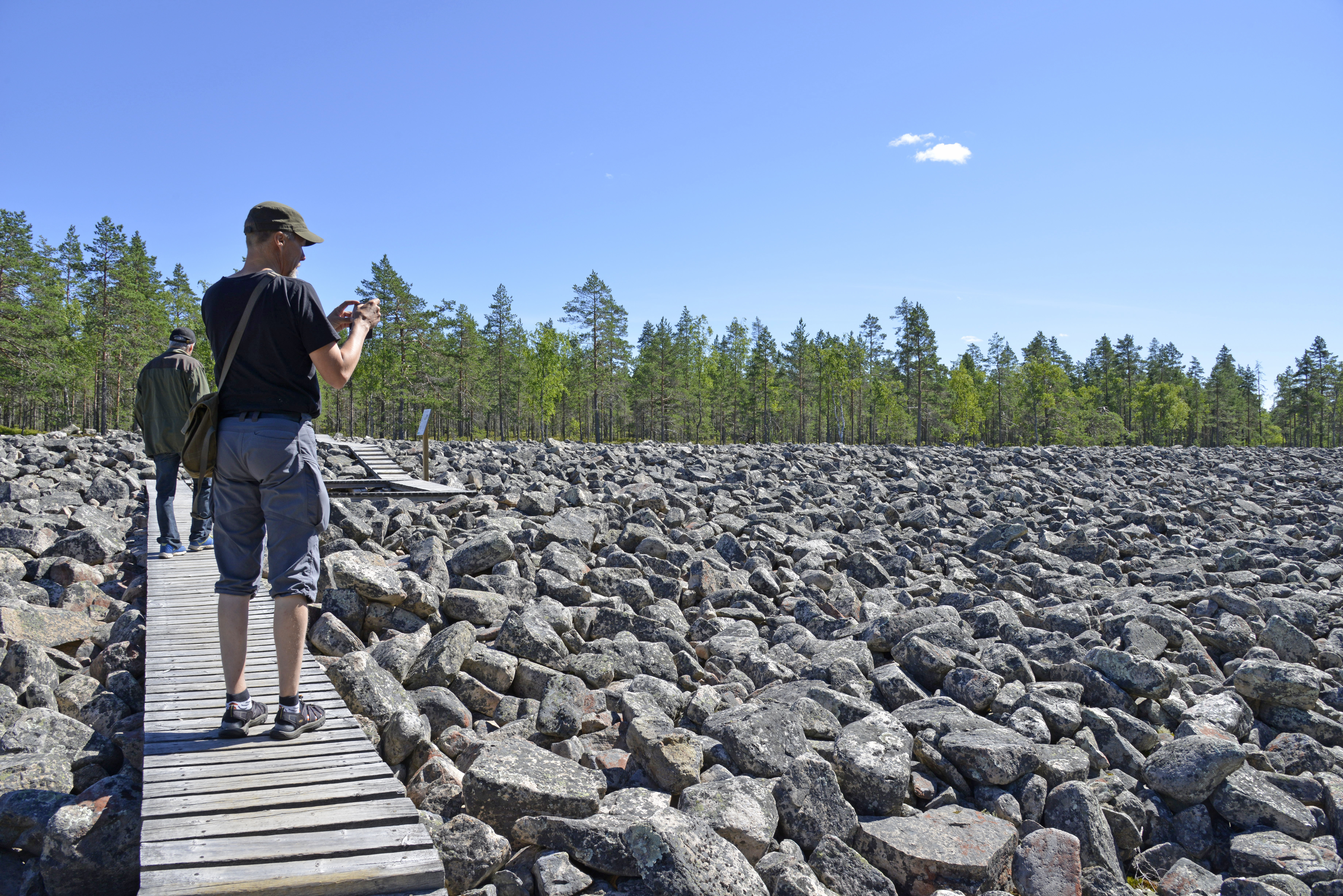 Miehiä Lauhanvuoren Kivijadan pitkoksilla aurinkoisena kesäpäivänä