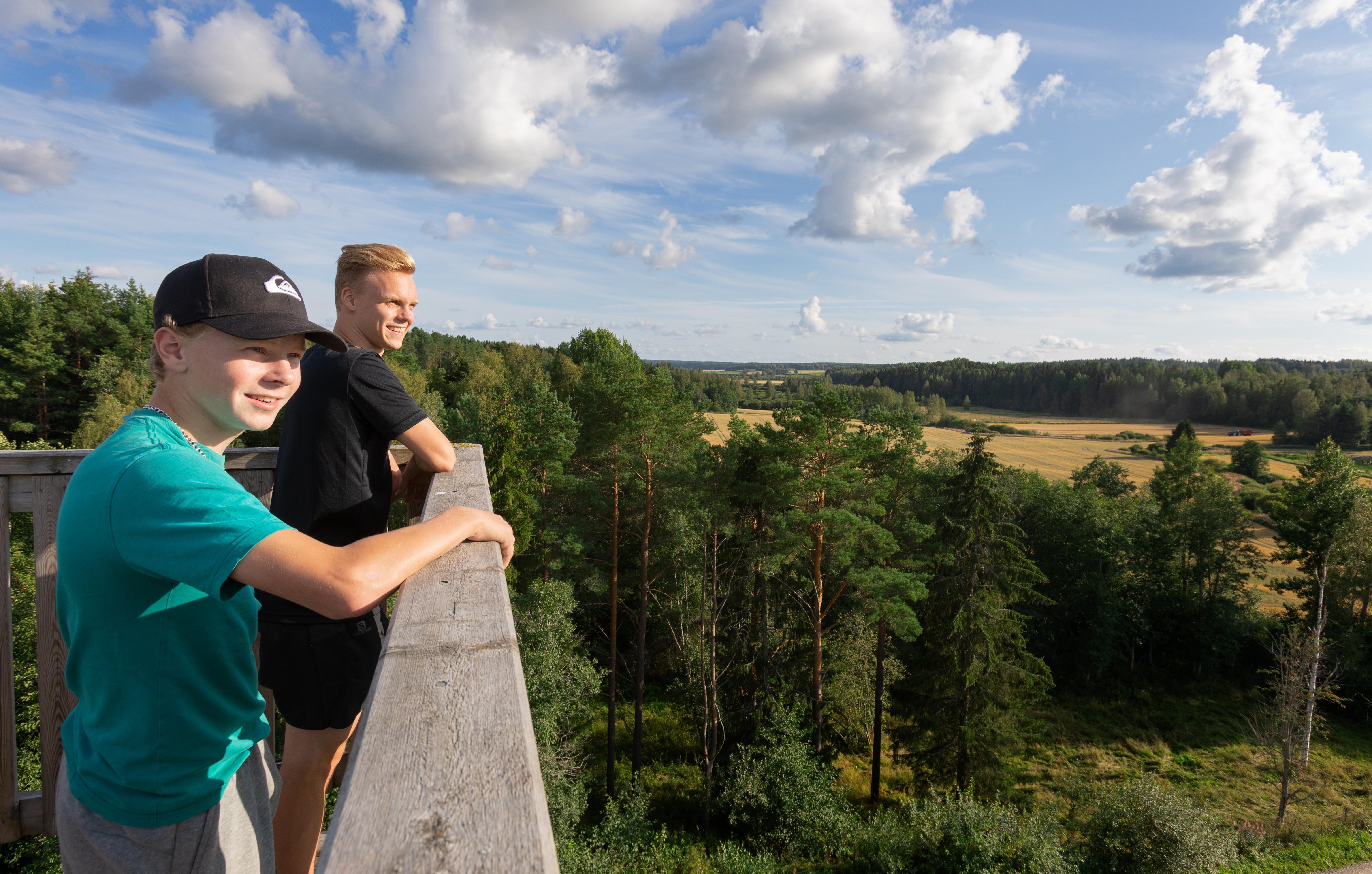 Nuoret miehet katselevat maisemia Hyypänjokilaakson näkötornista aurinkoisena loppukesän päivänä