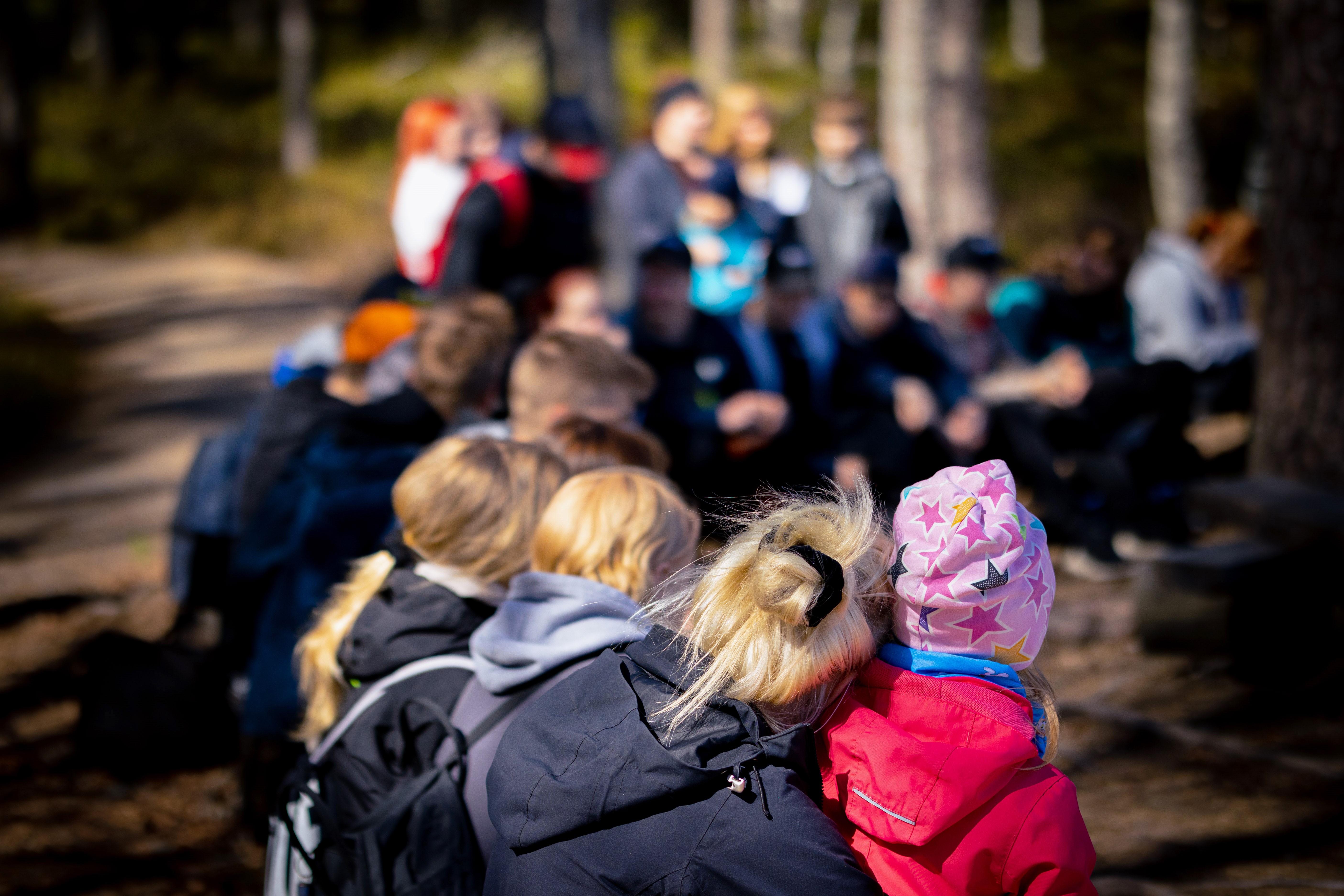 Kouluaisia istuskelemassa Lauhanvuoren Spitaalijärven nuotioringissä