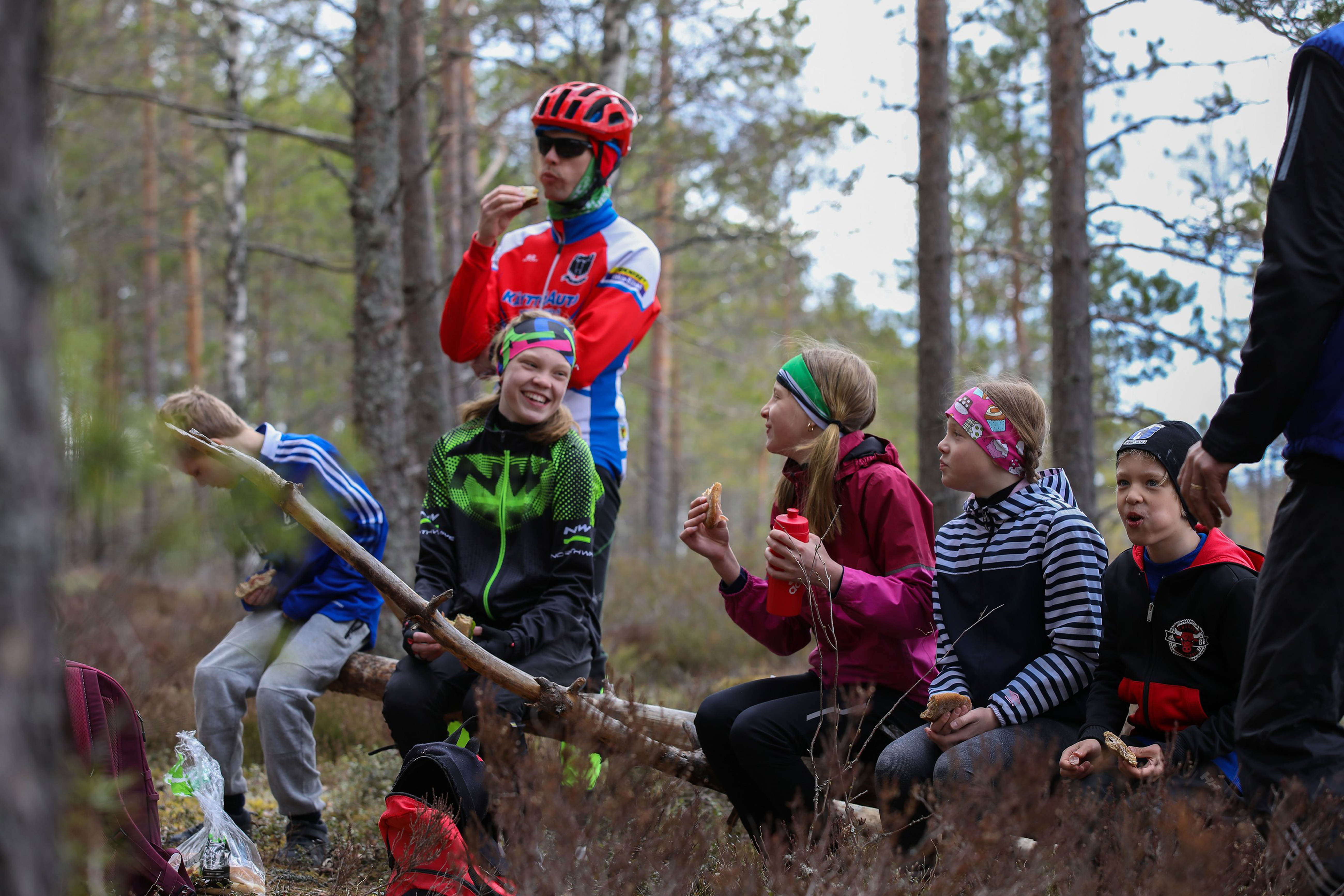 Iloisia pyöräilijöitä evästauolla metsässä